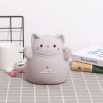 Hucha con forma de gato gris sobre una mesa