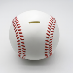 Hucha con forma de pelota de béisbol blanca con costuras rojas sobre fondo blanco limpio, representando una hucha deportiva moderna.